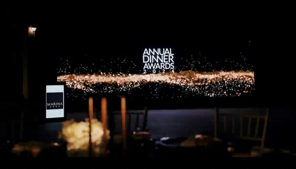 Annual Dinner Awards 2024 sign with sparkling decor at Marina venue, elegant evening setting.
